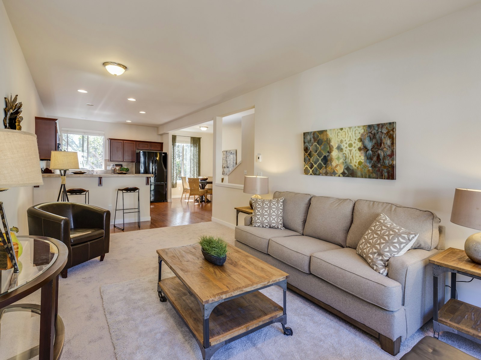 Bright, tidy living room with an open kitchen — sample stock photo